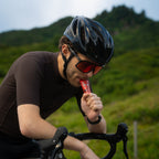 Cyclist taking a RocketFuel TRAIN gel on a mountain road