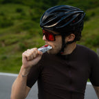 Cyclist taking a RocketFuel RACE+ gel