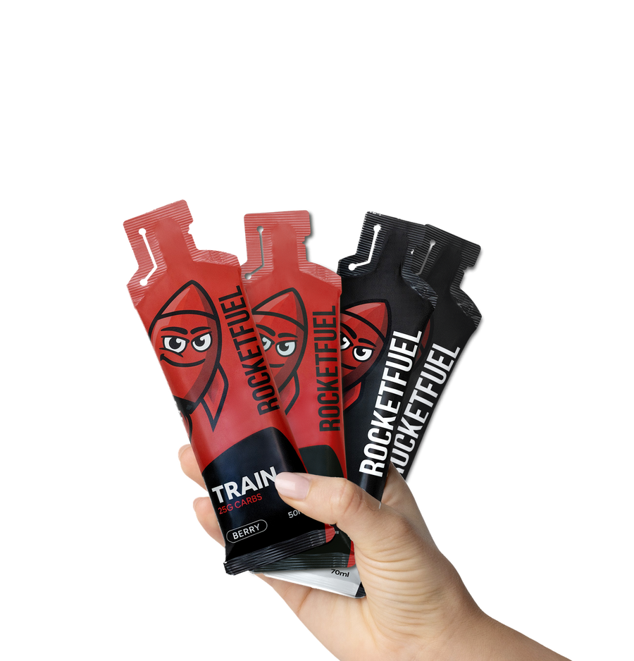Hand holding the RocketFuel Trial Pack: 2 TRAIN and 2 RACE gels